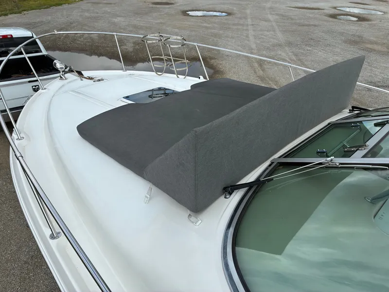 Slide: The Image of A 1998 Sea Ray 290 Sundancer with gray cushion on the foredeck, surrounded by railing. - 2