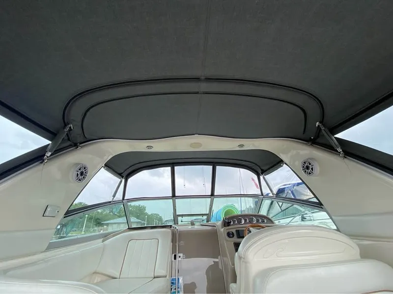Slide: The Image of Interior view of a 1998 Sea Ray 290 Sundancer with a gray canopy and white seating. - 7