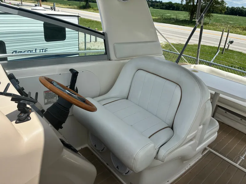 Slide: The Image of The image shows the helm of a 1998 Sea Ray 290 Sundancer with a white leather seat. - 11