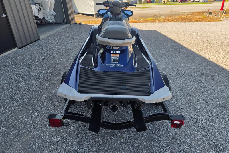 Slide: The Image of 2015 Yamaha WaveRunner VX Cruiser on trailer, parked on gravel near a building. - 2
