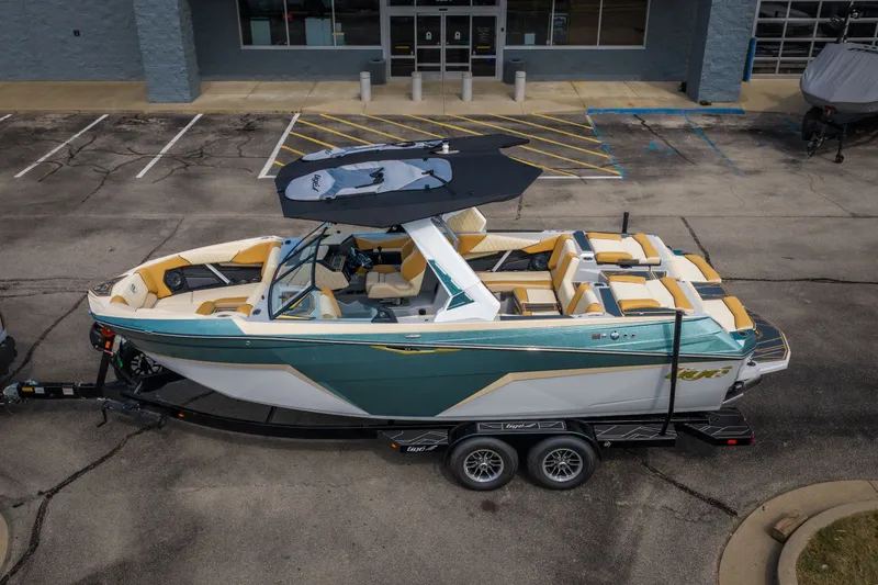 Slide: The Image of 2026 Tigé Z3 boat on trailer, teal and white design, parked outside a building. - 3