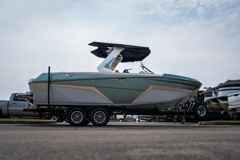 Slide: The Image of 2026 Tigé Z3 boat on trailer, sleek design, parked outdoors under cloudy sky. - 11