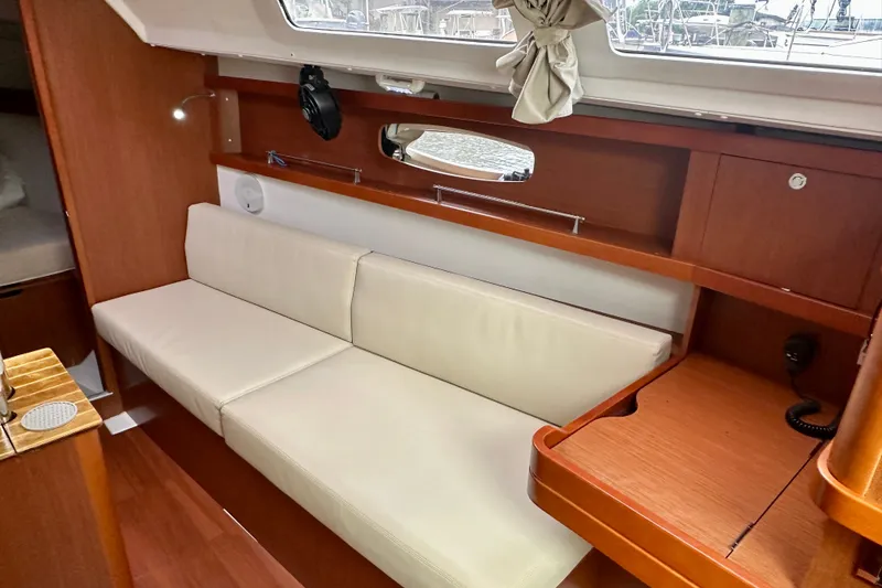 Slide: The Image of Interior of 2015 Beneteau Oceanis 31 yacht with white sofa and wooden cabinetry. - 14