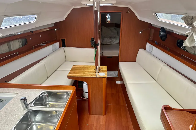 Slide: The Image of Interior of 2015 Beneteau Oceanis 31 sailboat with wood finish and white seating. - 12