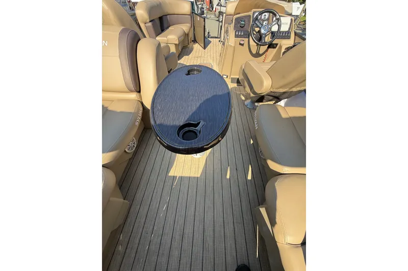 Slide: The Image of 2023 Sylvan Mirage X X1 boat interior with tan seating and a central table. - 20