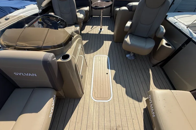 Slide: The Image of Interior of 2023 Sylvan Mirage X X1 boat with beige seating and wood-style flooring. - 12