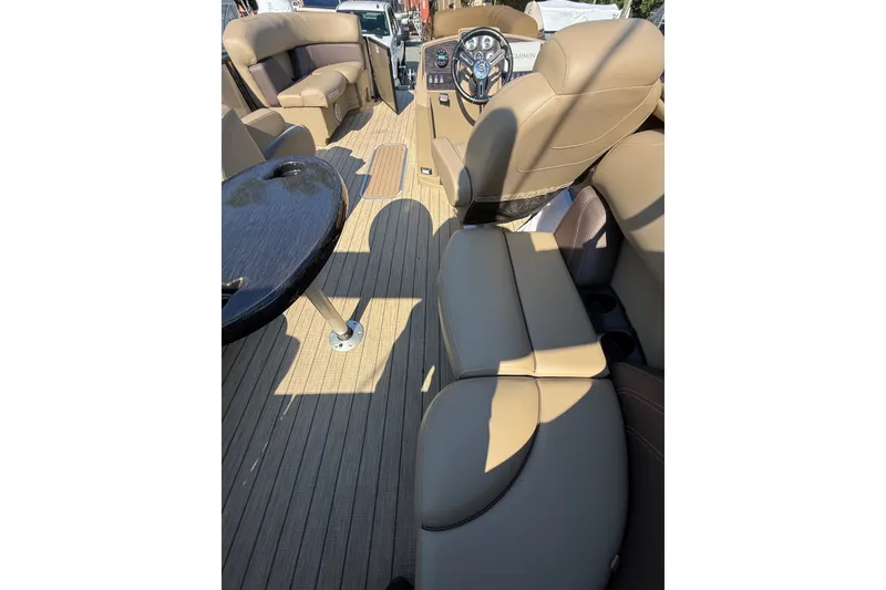 Slide: The Image of 2023 Sylvan Mirage X X1 boat interior with tan seating and sleek dashboard design. - 22