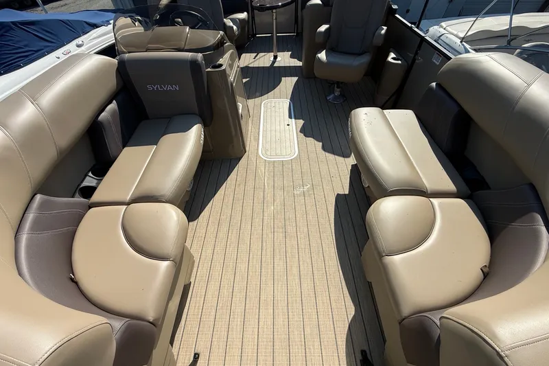 Slide: The Image of 2023 Sylvan Mirage X X1 boat interior with beige seating and spacious layout. - 10