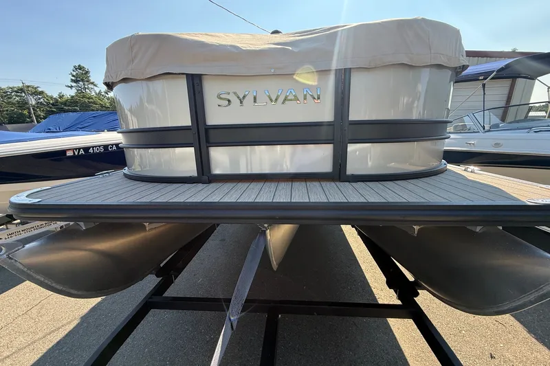 Slide: The Image of 2023 Sylvan Mirage X X1 pontoon boat with cover, displayed on a trailer. - 48