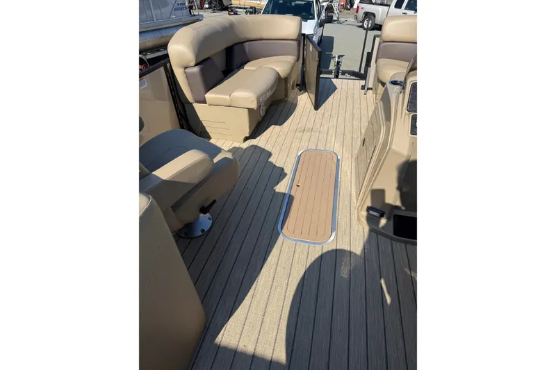 Slide: The Image of 2023 Sylvan Mirage X X1 boat interior with beige seating and wood-style flooring. - 24