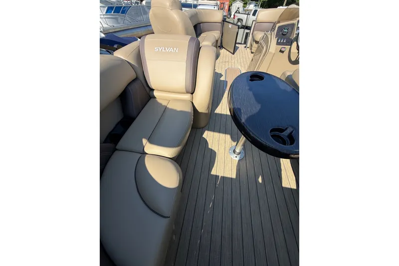 Slide: The Image of 2023 Sylvan Mirage X X1 boat interior with beige seating and a black table. - 21