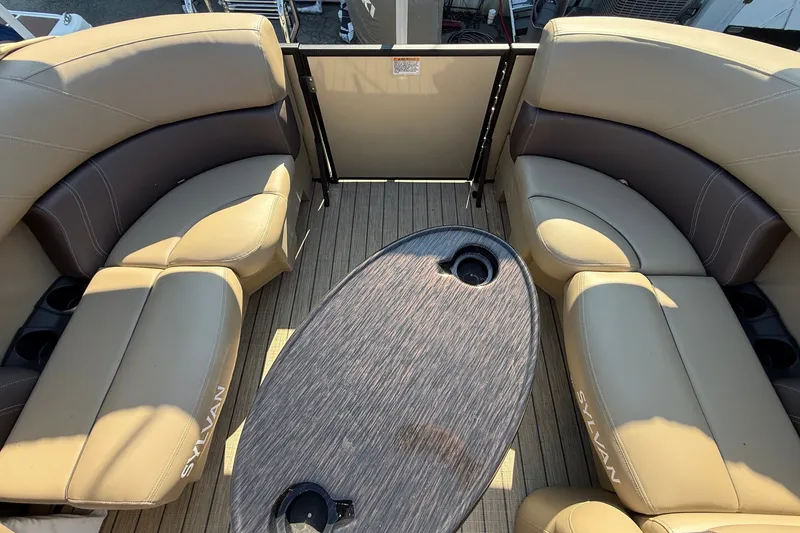 Slide: The Image of 2023 Sylvan Mirage X X1 boat interior with beige seating and oval table. - 15