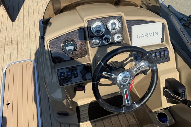 Slide: The Image of 2023 Sylvan Mirage X X1 boat dashboard with Garmin navigation system and steering wheel. - 25