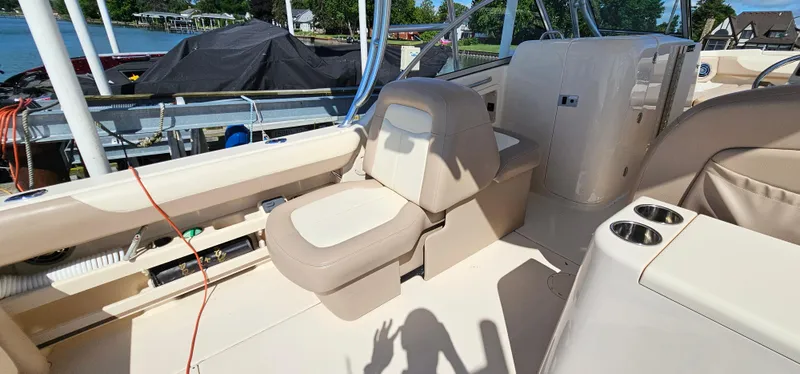 Slide: The Image of 2014 Grady-White Freedom 285 boat interior with beige seating and cup holders. - 10