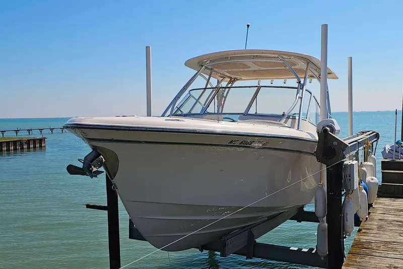 Slide: The Image of 2014 Grady-White Freedom 285 boat docked on a lift by the water. - 1