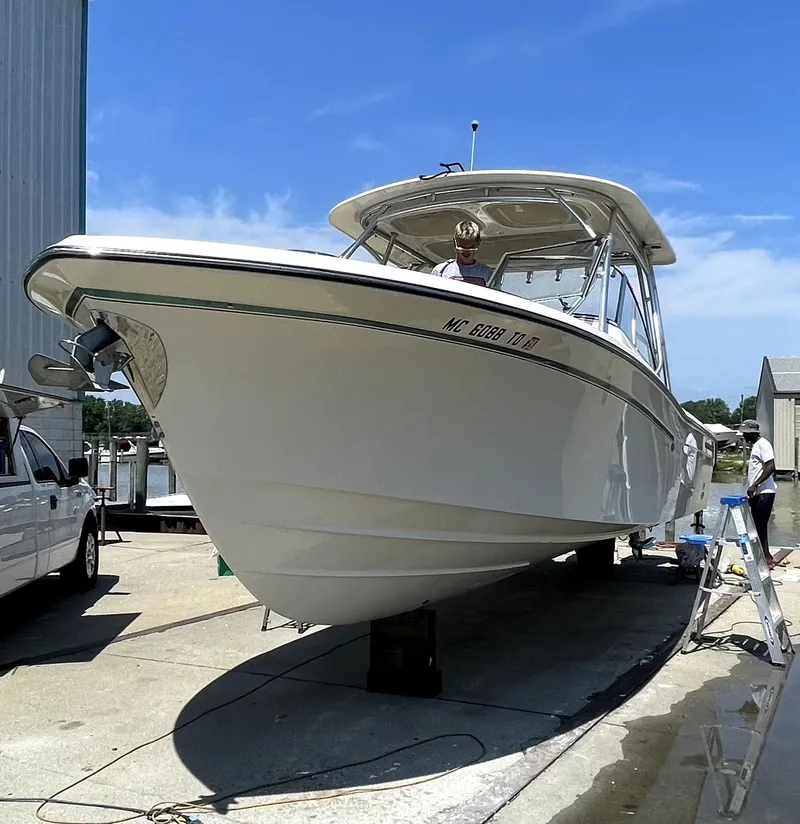 Slide: The Image of 2014 Grady-White Freedom 285 boat on dry dock under clear blue sky. - 3