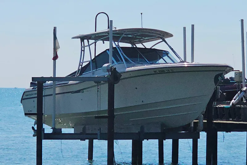 Slide: The Image of 2014 Grady-White Freedom 285 boat on lift by the water. - 2