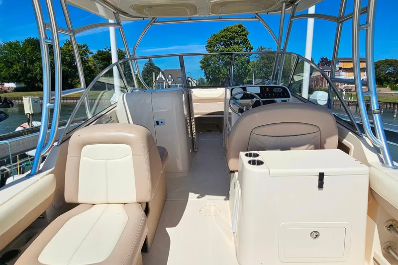 Slide: The Image of 2014 Grady-White Freedom 285 boat interior with seating and steering wheel, docked by water. - 7