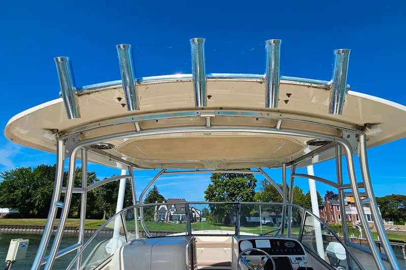 Slide: The Image of 2014 Grady-White Freedom 285 boat with T-top and rod holders, docked under clear blue sky. - 28
