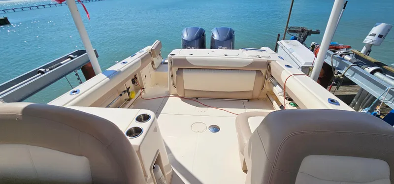 Slide: The Image of 2014 Grady-White Freedom 285 boat interior with dual engines, docked by the water. - 20