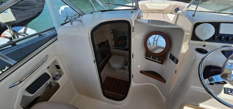 Slide: The Image of 2014 Grady-White Freedom 285 boat interior with open cabin door and visible toilet. - 22