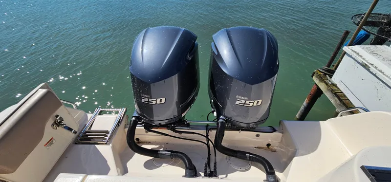Slide: The Image of Twin Yamaha 250 engines on a 2014 Grady-White Freedom 285 boat, docked by the water. - 26
