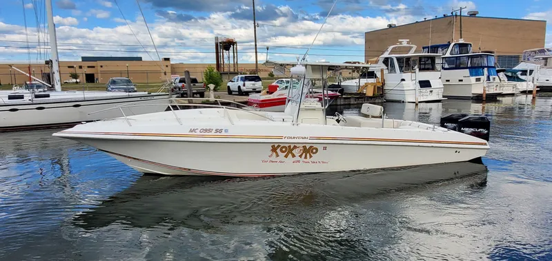 Slide: The Image of 1996 Fountain 31 Tournament Edition boat docked in a marina with other vessels. - 2