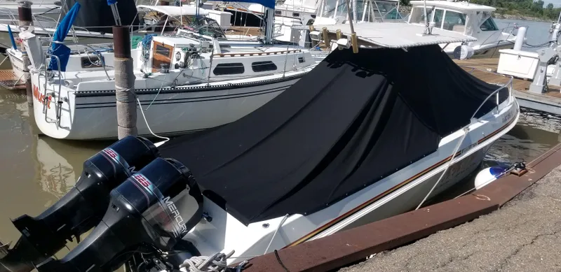Slide: The Image of 1996 Fountain 31 Tournament Edition boat docked with black cover and twin outboard motors. - 6