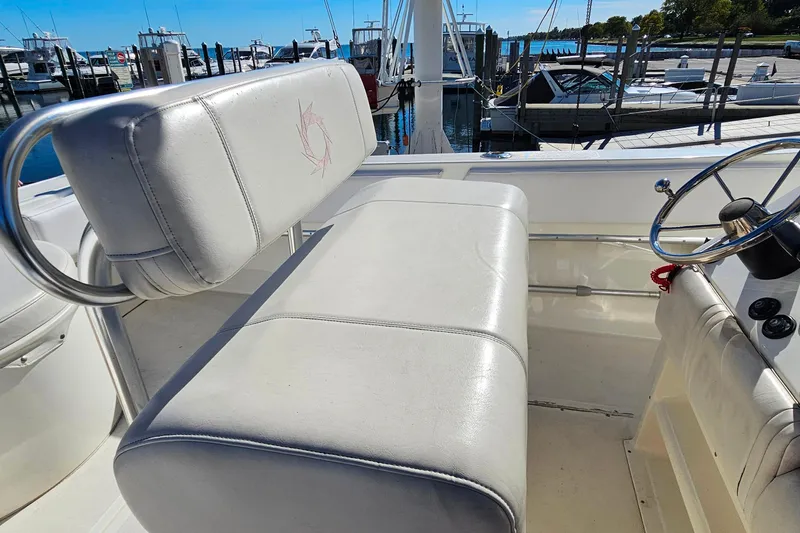 Slide: The Image of 1996 Fountain 31 Tournament Edition boat interior with white seating and steering wheel. - 23