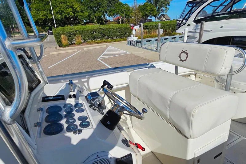 Slide: The Image of 1996 Fountain 31 Tournament Edition boat cockpit with steering controls and cushioned seating. - 21