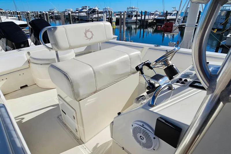 Slide: The Image of 1996 Fountain 31 Tournament Edition boat interior with helm and seating at marina. - 22