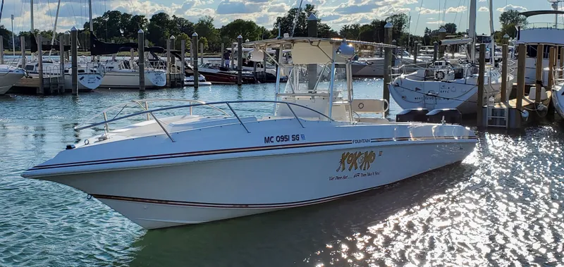 Slide: The Image of 1996 Fountain 31 Tournament Edition boat docked in a marina, reflecting sunlight on water. - 4