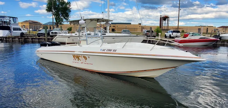 The Image of 1996 Fountain 31 Tournament Edition boat docked in a marina under a partly cloudy sky. - 1