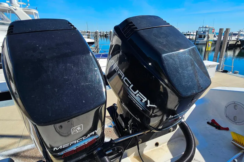 Slide: The Image of Twin Mercury outboard engines on a 1996 Fountain 31 Tournament Edition boat at a marina. - 37
