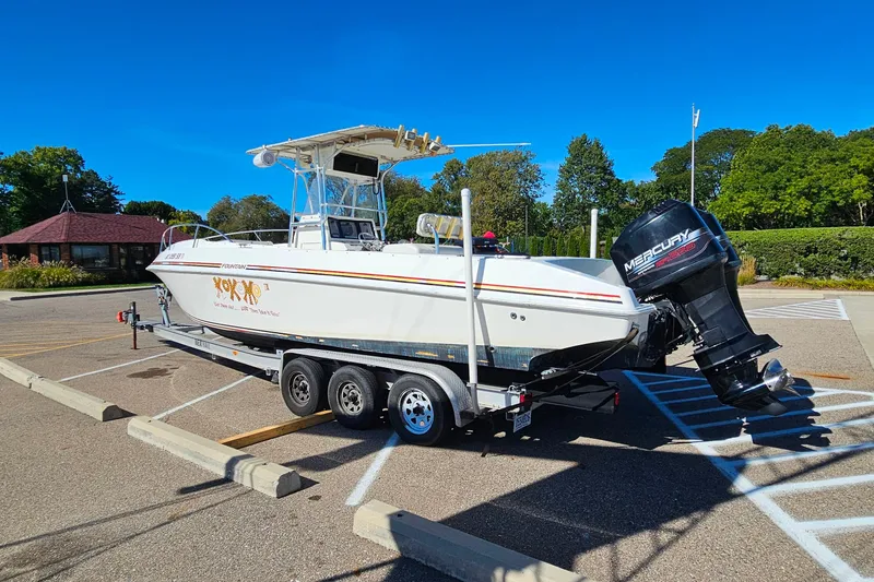 Slide: The Image of 1996 Fountain 31 Tournament Edition boat on trailer in parking lot, clear blue sky. - 8