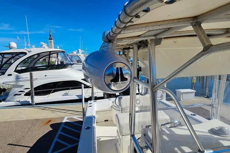Slide: The Image of 1996 Fountain 31 Tournament Edition boat with JL Audio speaker, docked near luxury yachts. - 31