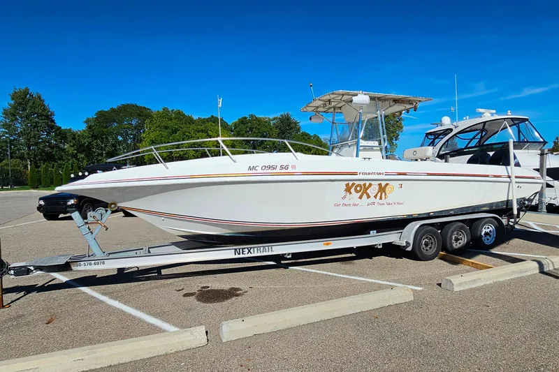 Slide: The Image of 1996 Fountain 31 Tournament Edition boat on trailer in parking lot, clear blue sky. - 7