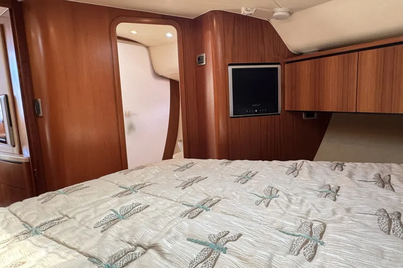 Slide: The Image of Luxurious 2008 Tiara Yachts 4300 Sovran cabin interior with wood paneling and cozy bedding. - 29