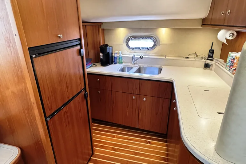 Slide: The Image of 2008 Tiara Yachts 4300 Sovran kitchen with wood cabinetry and dual sink. - 25