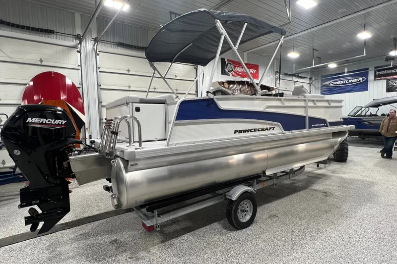 Slide: The Image of 2025 Princecraft Sportfisher 21-2S pontoon boat with Mercury engine in showroom. - 2