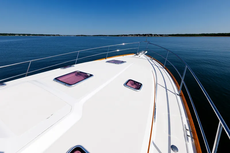 Slide: The Image of 2006 Sabre 42 Hard Top Express yacht deck on calm water under clear blue sky. - 47