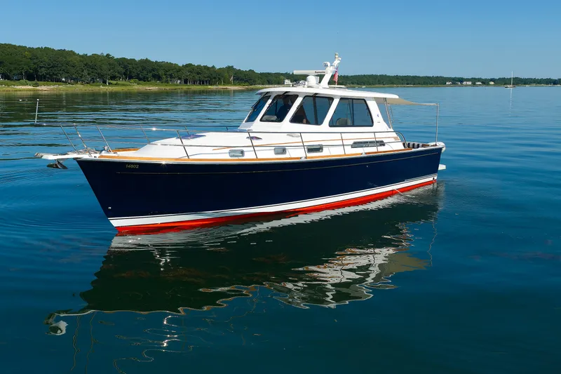 Slide: The Image of 2006 Sabre 42 Hard Top Express yacht on calm water, clear blue sky background. - 6