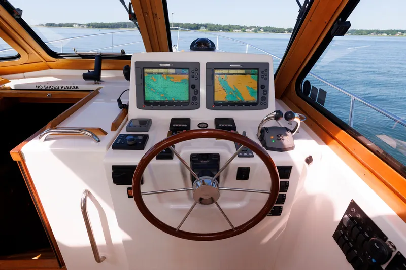 Slide: The Image of 2006 Sabre 42 Hard Top Express helm with navigation screens and wooden steering wheel. - 29