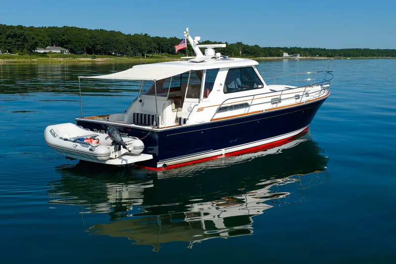 Slide: The Image of 2006 Sabre 42 Hard Top Express yacht on calm water, featuring a sleek design and canopy. - 12