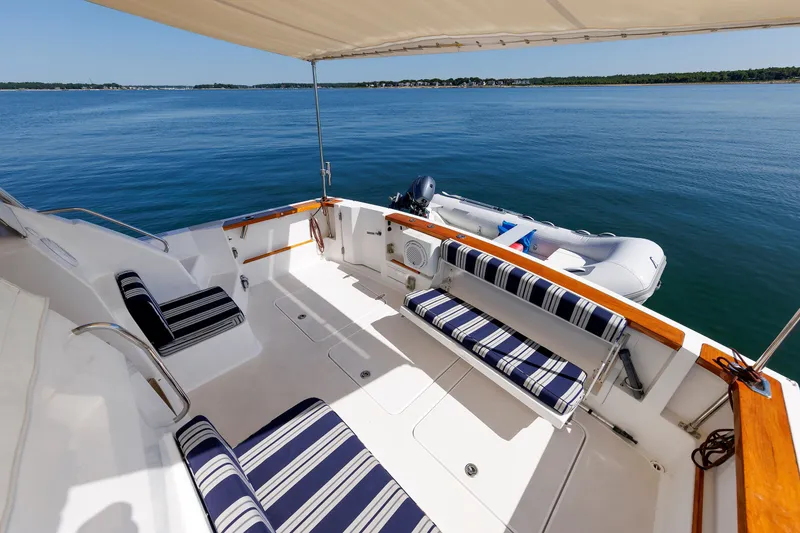Slide: The Image of 2006 Sabre 42 Hard Top Express yacht deck with striped seating and ocean view. - 13
