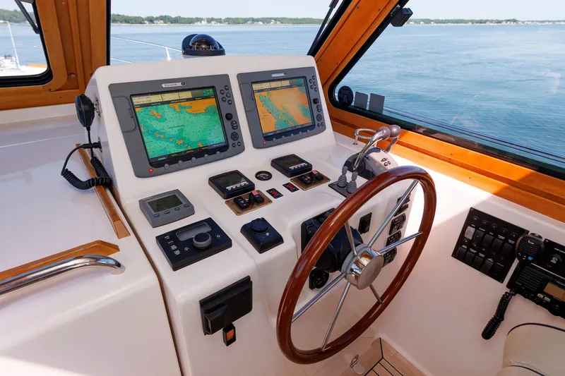Slide: The Image of Helm of 2006 Sabre 42 Hard Top Express with navigation screens and wooden steering wheel. - 28