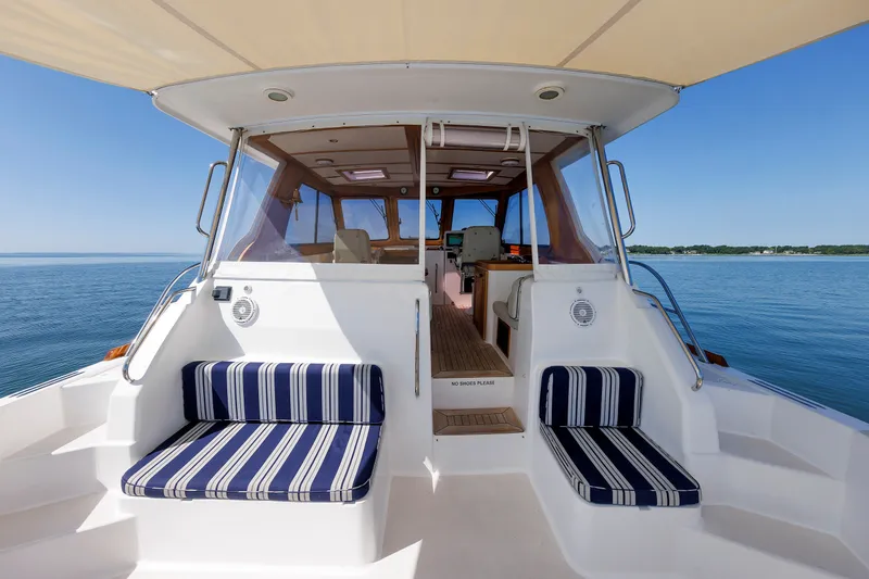 Slide: The Image of 2006 Sabre 42 Hard Top Express yacht with striped seating, cruising on calm waters. - 17