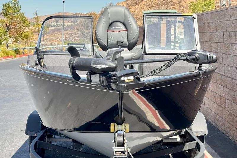Slide: The Image of 2022 Tracker Pro Guide V-175 Combo boat with Minn Kota trolling motor, parked outdoors. - 2