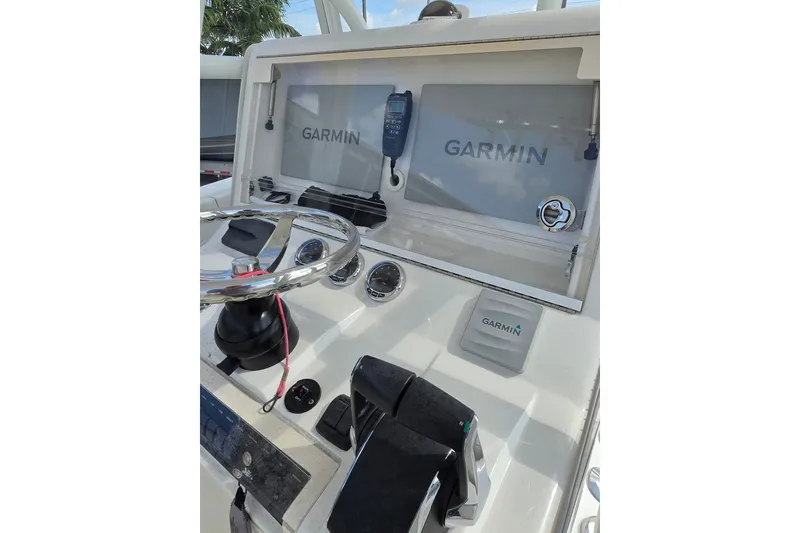Slide: The Image of 2023 SeaVee 340B boat dashboard with Garmin navigation displays and steering wheel. - 18