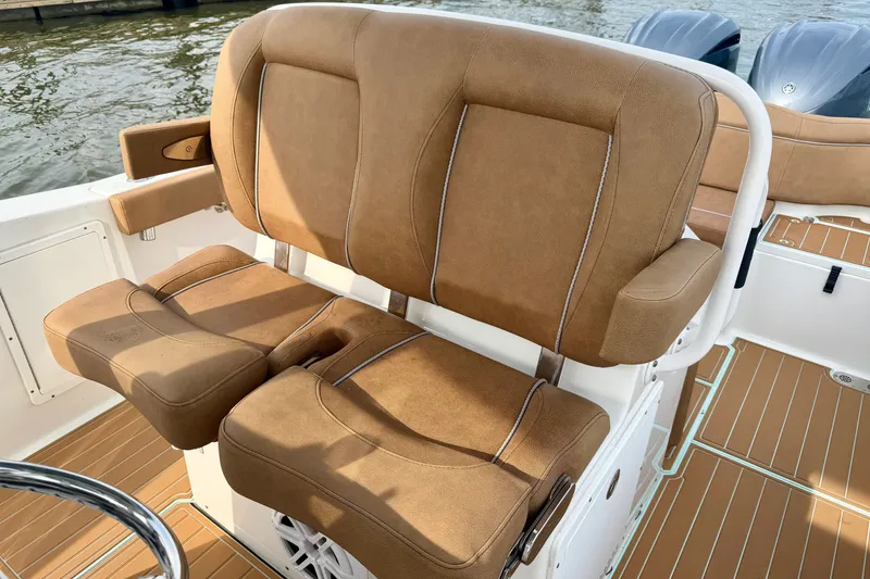 Slide: The Image of 2024 Sea Hunt Ultra 275SE boat with tan cushioned seating and dual engines. - 11